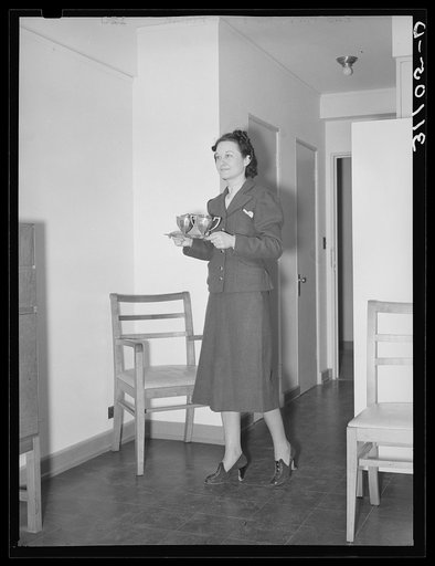 Serving tea in one of the one room-apartments. Greenbelt, Maryland