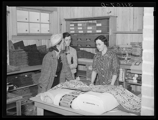 Southeast Missouri Farms. Customers examining yard goods in cooperative store. La Forge project, Missouri