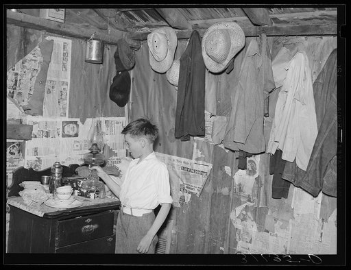 Southeast Missouri Farms. Sharecropper's son in corner of shack bedroom. La Forge project, Missouri