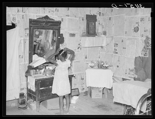 Southeast Missouri Farms. Sharecropper's child combing hair in bedroom of shack home near La Forge project, Missouri