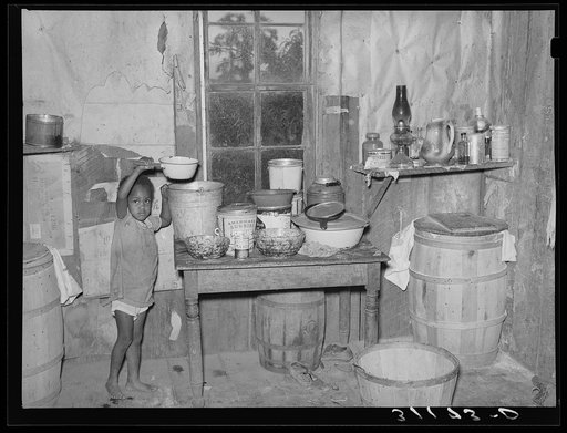 New Madrid County, Missouri. Child of sharecropper getting drink of water in kitchen of shack