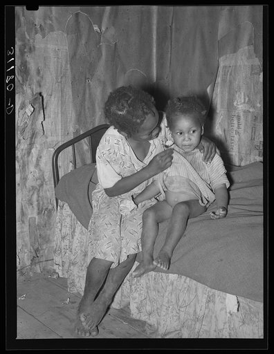 New Madrid County, Missouri. Child of sharecropper wiping baby's nose in cabin