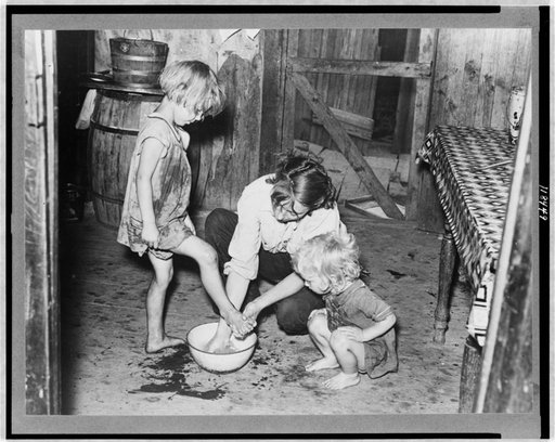 Mother washing feet and cleaning up daughters in sharecropper's shack.  Southeast Missouri Farms