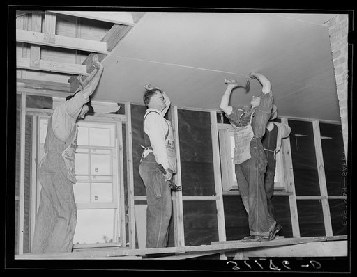 Untitled photo, possibly related to: Southeast Missouri project field. House erection. Nailing on finished ceiling of 4' x 7' insultation board