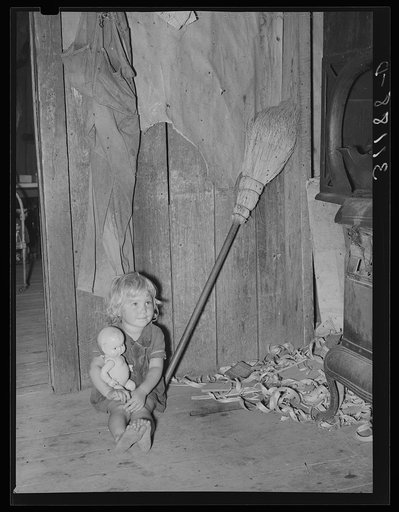Southeast Missouri Farms. Daughter of sharecropper with doll on kitchen in shack home