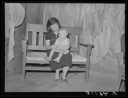 Southeast Missouri Farms. Mother and child sitting on settee in sharecropper cabin