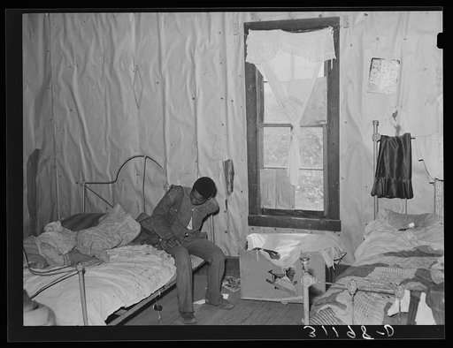 Southeast Missouri Farms. Son of sharecropper getting dressed in bedroom of shack