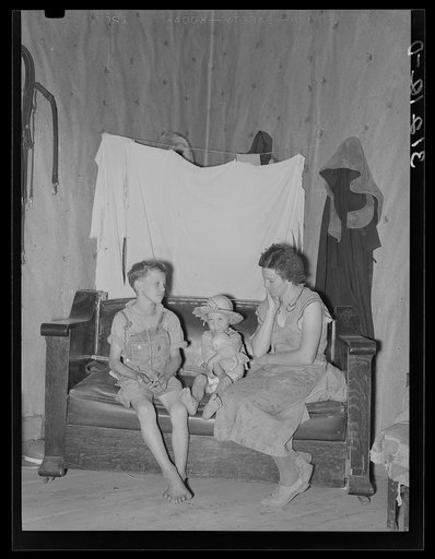 Sharecropper mother and children in corner of living room. Southeast Missouri farms