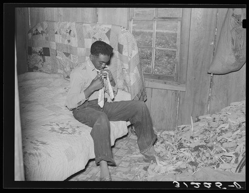 Southeast Missouri Farms. Son of sharecropper dressing in combination bedroom and corn crib