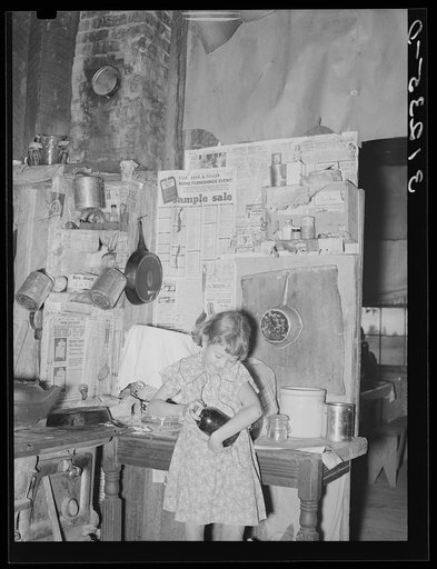 Southeast Missouri Farms. Child of sharecropper opening jar of fruit in kitchen