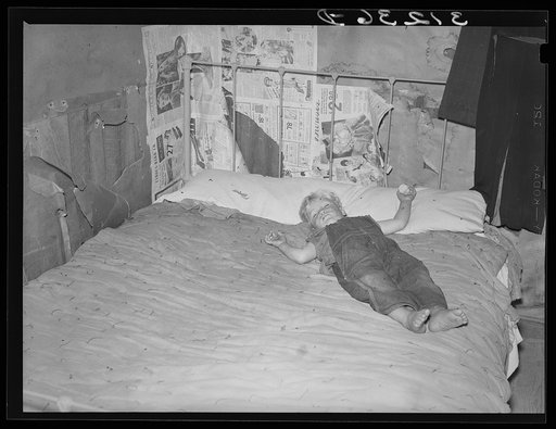 Southeast Missouri Farms. Child of FSA (Farm Security Administration) client, former sharecropper, asleep on bed in bedroom of shack home