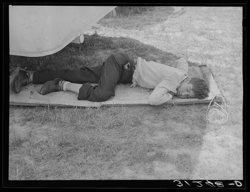 Member of carnival crew resting on hammock. Lasses-White traveling show.  Sikeston, Missouri