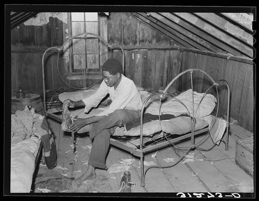 Untitled photo, possibly related to: Boy on bed in attic of sharecropper shack. New Madrid County, Missouri