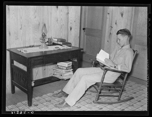 Son of Atkinson family reading at new home. Southeast Missouri Farms