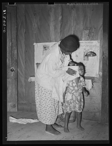 Wife of sharecropper washing daughter's face. Family will participate in tenant purchase program. Near Caruthersville, Missouri