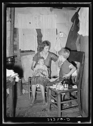 Girl tending fire in shack home. Tin Town, Caruthersville, Missouri