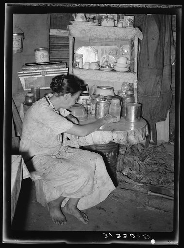 Resident of Tin Town, Caruthersville, Missouri, sitting at kitchen table