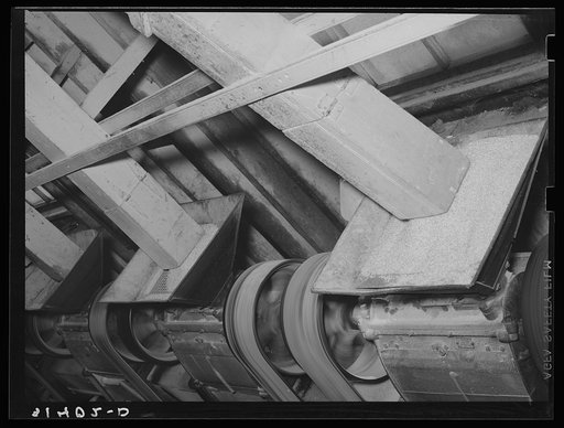 Rice being fed into polishing machine from chutes. Abbeville, Louisiana