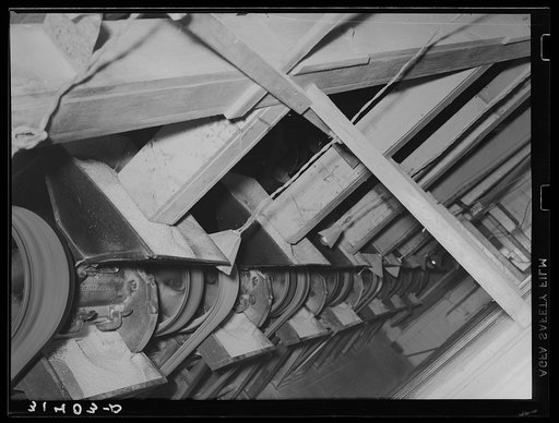 Rice being fed into polishing machine from chutes. Abbeville, Louisiana