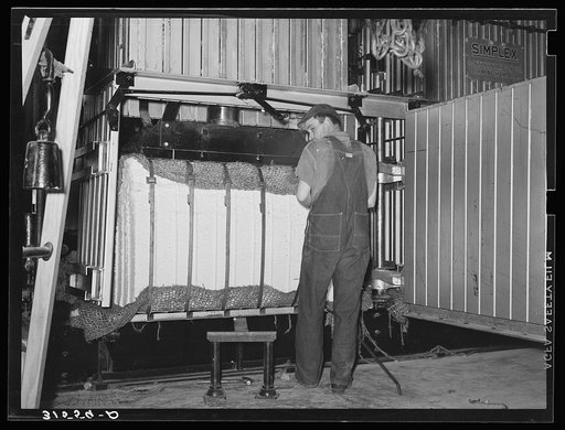 Untitled photo, possibly related to: Bale of cotton immediately after compressing, being tipped out of baler. Lake Dick Project, Arkansas