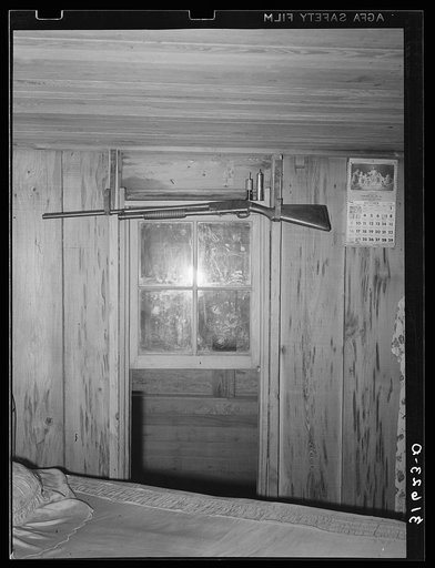 Repeating shotgun over the window in bedroom of Cajun farm family near Crowley, Louisiana