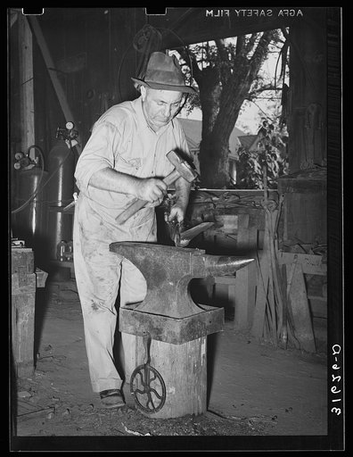 Blacksmith at work shaping knife for farm implement. Abbeville, Louisiana