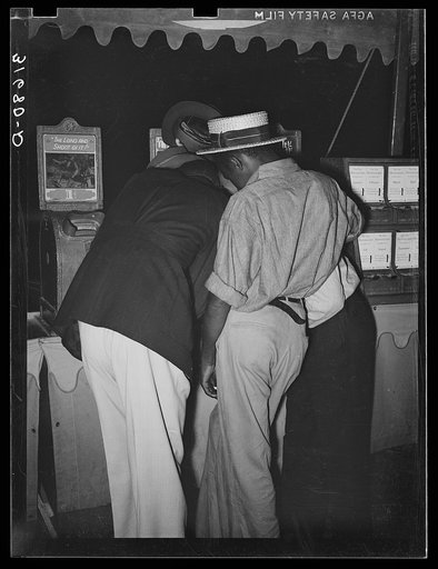 Untitled photo, possibly related to: Boys looking at penny movies at South Louisiana State Fair. Donaldsonville, Louisiana