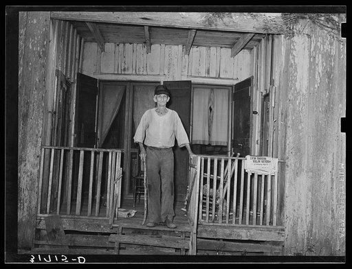 Old man standing on front of recessed porch in house near Lutcher, Louisiana