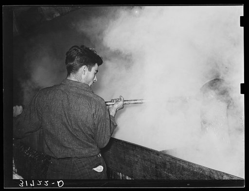 Ladling syrup from boiling vat to concentration vat at syrup mill near New Iberia, Louisiana