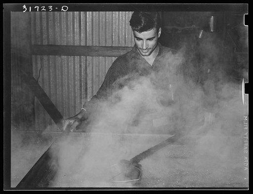 Skimming boiling sugarcane juice in process of syrup making near New Iberia, Louisiana