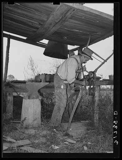 W.E. Smith, farmer near Morganza, Louisiana, doing blacksmith work on plow in his improvised blacksmith shop