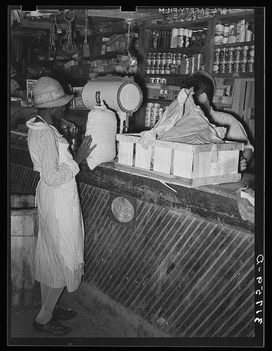 Negro woman trading sack of pecans for groceries in general store. Jarreau, Louisiana