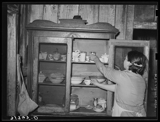 Mrs. M. LaBlanc removing supplies from screened safe. Because of general lack of screens in the house, it is necessary that some means be provided to keep flies from food. Morganza, Louisiana