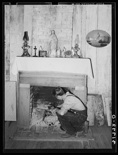 Son of M. LaBlanc building a fire in present farm home. Morganza, Louisiana. The LaBlancs are tenant purchase clients