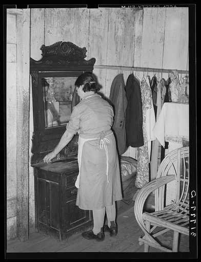 Mrs. M. LaBlanc arranging articles on dresser. Note improvised closet space in this home. La Blancs will be tenant purchase clients