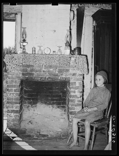 Untitled photo, possibly related to: Daughter of Cajun day laborers sitting in front of fireplace in home near New Iberia, Louisiana