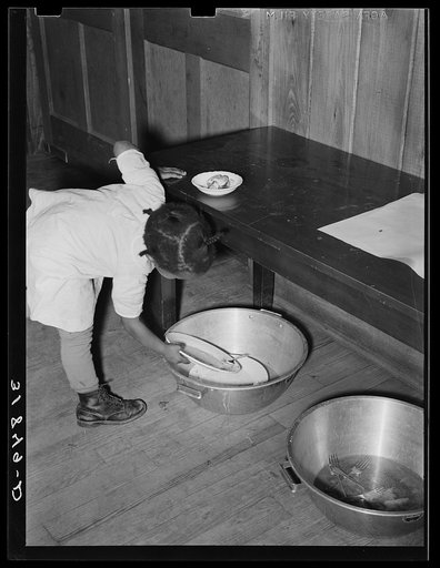 Children in nursery school at Lakeview Project, Arkansas, are taught to take the dishes from table and place them in pans for washing