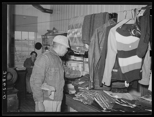 Member of Lakeview Cooperative Association examining clothing in general store. Arkansas