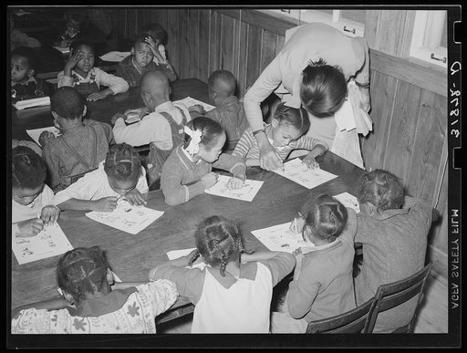 Children receiving instructions in coloring drawings. Lakeview Project, Arkansas