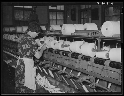 Worker winding cotton thread onto large spools. Laurel cotton mills, Laurel, Mississippi