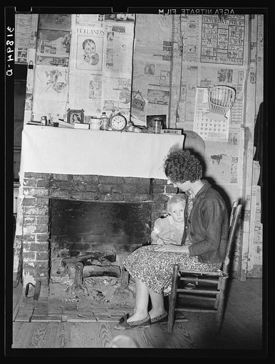 Wife and daughter of FSA (Farm Security Administration) client in front of fireplace of temporary home. Transylvania, Louisiana