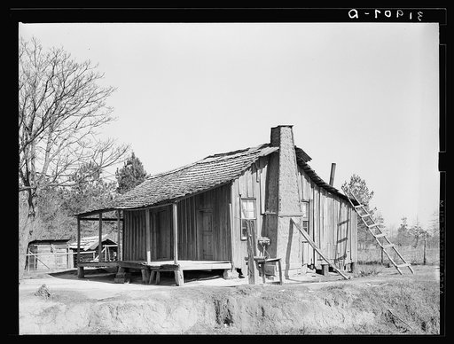 Negro cabin, showing grass and mud chimney and broom made of corn husks for sweeping yard. Taylorsville, Mississippi