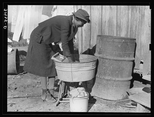 Washing clothes at rear of sharecropper's cabin. Transylvania, Louisiana