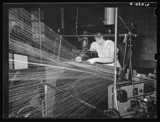 Operator repairing break in thread in warp winding. Laurel cotton mills, Laurel, Mississippi