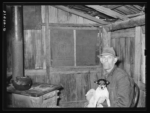 Mot Tucker in kitchen of his corncrib home. Note nitrate of soda sacks used for shades in windows. Antioch, Mississippi