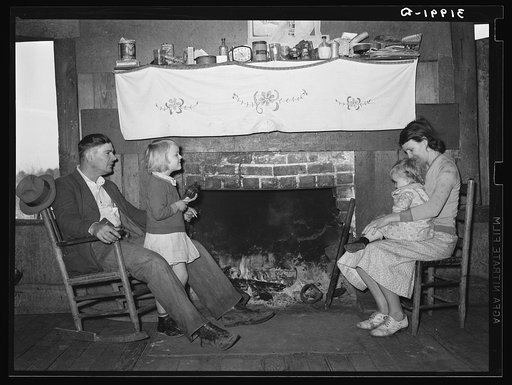 Bagget family in front of fireplace which is means of heating in the winter. Laurel, Mississippi