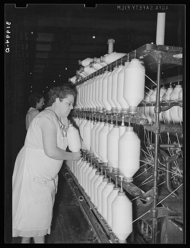 Removing spindles of large cotton thread from thread-making machinery. Laurel cotton mill, Laurel, Mississippi