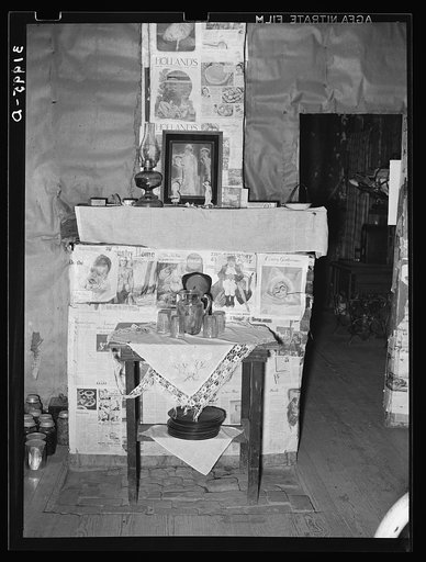Fireplace closed with screen decorated with newspapers in temporary home of FSA (Farm Security Administration) clients near Transylvania, Louisiana