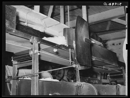 Untitled photo, possibly related to: Cotton from the bale is transported by belt to machine for making cotton bats. Weighing device is so sensitive that it directs the cotton from one machine to another. Laurel, Mississippi