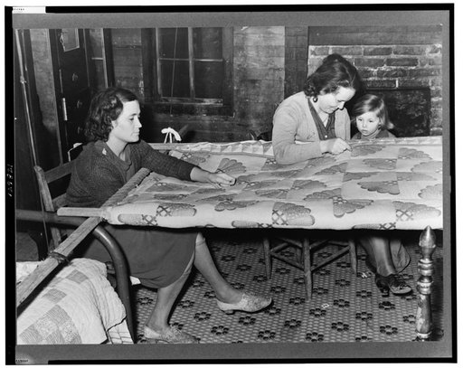 Quilting in sharecropper's home near Pace, Mississippi. Background photo for Sunflower Plantation